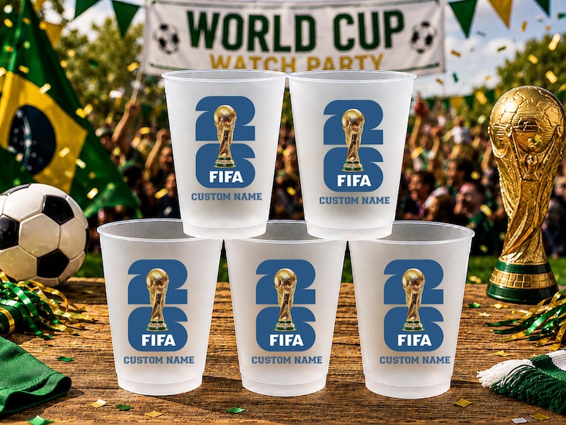 May include: A set of frosted plastic cups with a blue and gold FIFA World Cup design. Each cup features the number 23, a trophy graphic, and the text "FIFA CUSTOM NAME". A golden trophy and football are also visible.