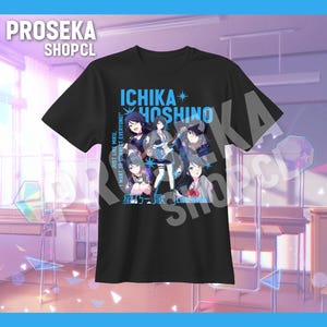 Puede incluir: Camiseta negra con un gráfico de personajes de anime y el texto azul "ICHIKA HOSHINO". El diseño incluye texto japonés y la frase blanca "JUST LIKE MIKU, I WANT TO CONNECT EVERYONE!". La camiseta se muestra sobre un fondo azul.