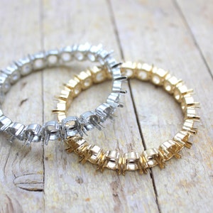 Puede incluir: Dos engastes de anillo de metal para piedras preciosas. Uno es de plata y el otro es de oro.