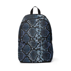 Peut inclure: Un sac à dos avec un motif peau de serpent bleu foncé et noir. Le sac possède un grand compartiment principal avec fermeture éclair, une poche avant plus petite avec fermeture éclair, une poignée supérieure et des bretelles réglables.