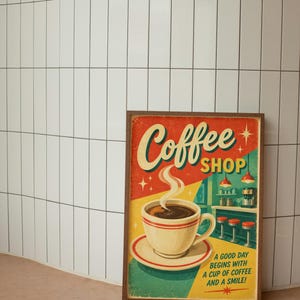 May include: A rectangular framed wall art print featuring a retro illustration of a coffee cup on a saucer. The text reads Coffee SHOP and A GOOD DAY BEGINS WITH A CUP OF COFFEE AND A SMILE! The background depicts a diner counter with red stools.