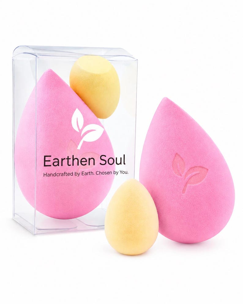May include: Pink teardrop-shaped makeup sponges with a leaf logo and the text "Earthen Soul". Two yellow egg-shaped sponges are also visible. The sponges are packaged in a clear plastic box. The text "Handcrafted by Earth. Chosen by You." is also visible.