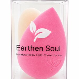 May include: A clear plastic box containing two makeup sponges. One is a bright pink teardrop shape with a white leaf design and the text "Earthen Soul". The other is a light beige oval shape.