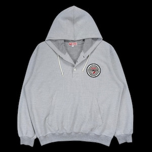 May include: A light grey pullover hoodie featuring a button-up placket at the neckline, a hood with white drawstrings, and a circular patch on the chest displaying the text TRD Toyota Racing Development in red, white, and black colours.