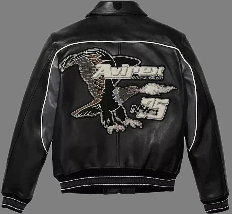 May include: Black leather jacket with white trim and a ribbed hem. The back features a large embroidered eagle graphic with the brand name "Avirex" and the number "75".