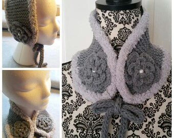 May include: A grey crocheted cowl with a fluffy white trim and two grey crocheted flowers with pearl centres. The cowl has a grey crocheted tie.