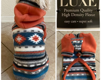 May include: A red hooded fleece dog sweater with a southwestern-style geometric pattern in shades of blue, white, and orange. The sweater is labelled "LUXE Premium Quality High Density Fleece easy care - super soft".