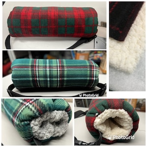 May include: A green and red plaid fabric neck pillow with a soft, white fleece lining. The pillow has a black adjustable strap.