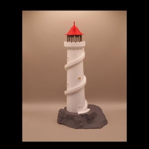 Op de afbeelding: Een wit vuurtorenmodel met een felrood kegelvormig dak, een donkerbruine galerijreling en een opvallende externe wenteltrap die rond de toren loopt. De structuur is gemonteerd op een getextureerde, donkergrijze rotsachtige basis.