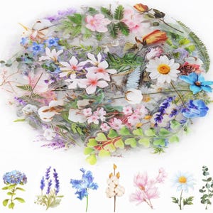 May include: A collection of floral stickers featuring a variety of flowers in shades of pink, white, blue, and yellow. The stickers include daisies, roses, and other floral designs. Additional individual flower stickers are displayed below the main collection.