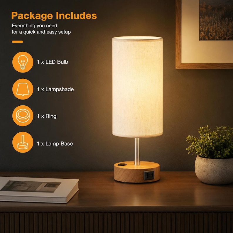 May include: A cylindrical table lamp with a light-coloured fabric shade, a silver metal stem, and a round wooden base featuring a power switch and a USB port. Text on the left lists the package contents: 1 x LED Bulb, 1 x Lampshade, 1 x Ring, 1 x Lamp Base.