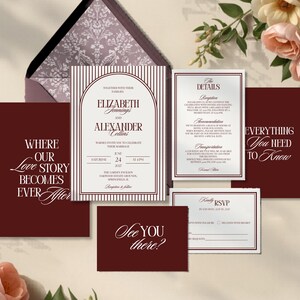 May include: A collection of burgundy and white wedding stationery, including an invitation, RSVP card, and details card. The invitation features the names "Elizabeth Jennings" and "Alexander Collins". The stationery is arranged with floral accents.