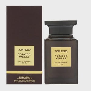 May include: A dark brown rectangular perfume bottle and box set. The bottle has a black cap and a yellow label with the text "TOM FORD TOBACCO VANILLE EAU DE PARFUM 100 ML". The box has the same label.