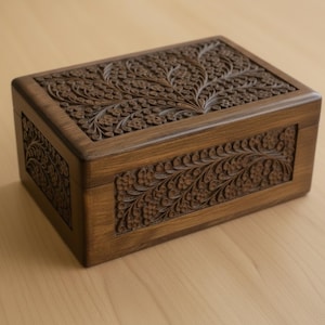 May include: A rectangular wooden box with intricate floral carvings on the lid and sides. The box is stained a warm brown color, highlighting the detailed patterns. The design features a symmetrical arrangement of flowers and leaves.