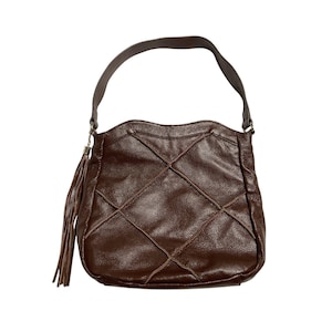 May include: A brown leather shoulder bag with a stitched diamond pattern. The bag has a single handle and a decorative tassel. The bag is made of a textured leather material.