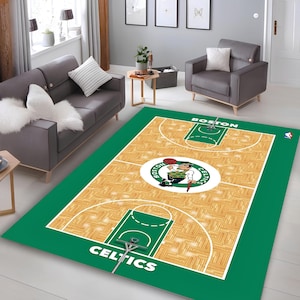 May include: A rectangular rug featuring a basketball court design with the Boston Celtics logo at the center. The rug has a green border and a wooden floor pattern. The word "BOSTON" is at the top, and "CELTICS" is at the bottom.