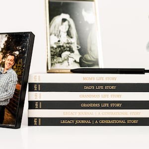 May include: A stack of black and white journals with gold lettering. The titles of the journals are "Mom's Life Story", "Dad's Life Story", "Grandma's Life Story", "Grandpa's Life Story", "Legacy Journal | A Generational Story", and "Legacy Journal | A Generational Story".