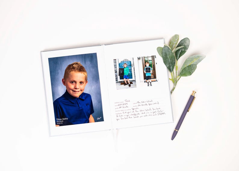 K&ouml;nnte beinhalten: Ein wei&szlig;es Fotoalbum mit einem blauen Hintergrundfoto eines Jungen, der ein blaues Hemd tr&auml;gt. Das Album ist auf einer Seite mit einer handschriftlichen Nachricht und zwei kleineren Fotos des Jungen vor einer Schule ge&ouml;ffnet.