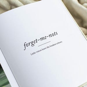 May include: Open book with the words "forget-me-nots" in a delicate serif font, underlined. Below, the text reads "Little voices leave the loudest echoes." The pages are white, and the book is open on a soft, neutral-toned surface.