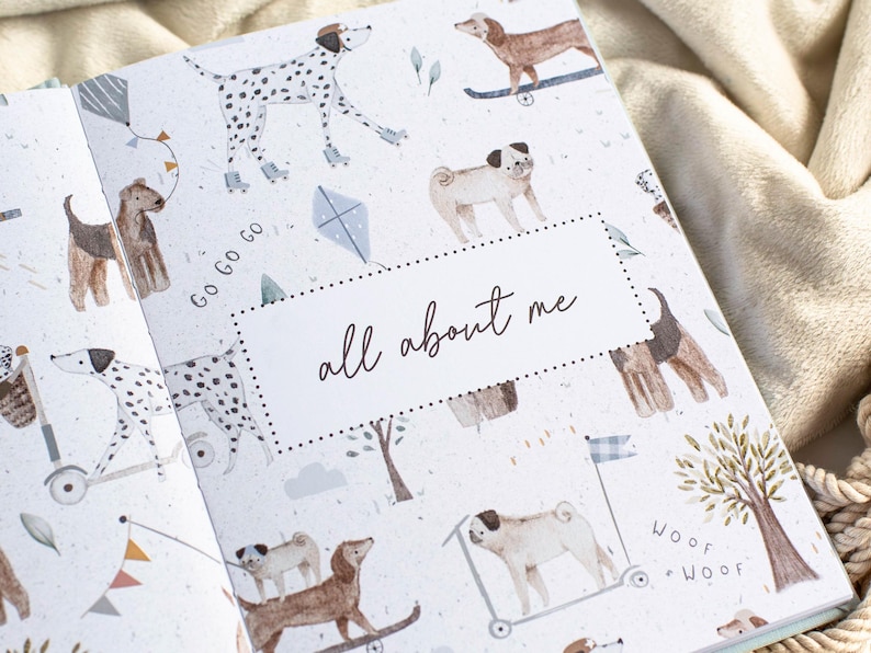 May include: Open book with a patterned cover featuring illustrations of various dog breeds, kites, and trees. The text "all about me" is centered on a white dotted rectangle. The background is a soft, neutral color.