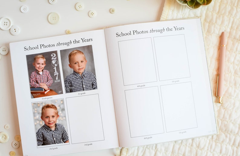 May include: A school photo album with blank spaces for photos from kindergarten through 8th grade. The album has a white background and black text. The album is open to a page with photos of a young boy in kindergarten, 1st, and 2nd grade.
