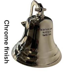 May include: A chrome-finished bell with a curved handle and a clapper. The bell has the inscription "To Our Favorite Captain, We Will Miss You, Your MSC Family". The bell is a nautical-themed item.