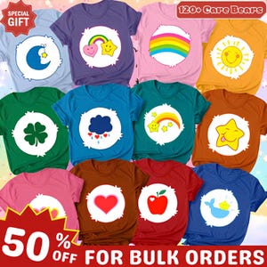 Peut inclure: Une collection de onze t-shirts colorés présentant divers motifs de badges ventraux Care Bears, incluant une lune, un arc-en-ciel, un soleil, un trèfle, un nuage, une étoile, un cœur, une pomme et une baleine, disposés en grille avec du texte.