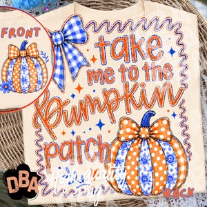 May include: A cream-colored t-shirt featuring a graphic design with the text "take me to the Pumpkin patch". The design includes two pumpkins with orange and blue patterns, a blue gingham bow, and small star accents, all framed by a wavy blue border.
