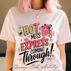 May include: White t-shirt with a pink and gold graphic that says "Hot Mess Express Coming Through!" with a coffee cup and makeup bag.