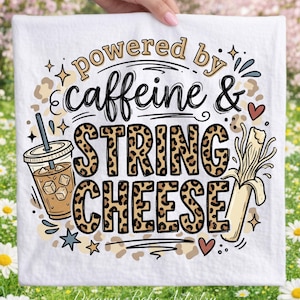 May include: White kitchen towel with the text "powered by caffeine & string cheese". The words are in various fonts and colours, with a leopard print pattern on "string cheese". Features a coffee drink and a banana illustration.