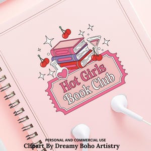 Op de afbeelding: Een roze spiraalgebonden notitieboek met een afbeelding van boeken, kersen en een cocktailglas. De tekst "Hot Girls Book Club" staat op een roze banner. Witte oortelefoons liggen op het oppervlak van het notitieboek.