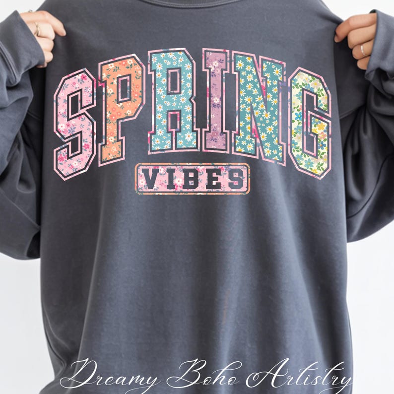 May include: Dark gray sweatshirt with the words "SPRING VIBES" in a floral design. The word "SPRING" is in large, block letters with a floral pattern in pink, orange, and blue. The word "VIBES" is in a smaller rectangle.