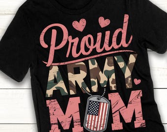 May include: Black t-shirt with pink text that reads "Proud Army Mom". The text is layered over a camouflage pattern. A pink heart is to the right of the text. A silver dog tag with an American flag is hanging from a chain below the text.