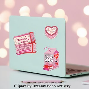 Op de afbeelding: Een laptop met stickers, waaronder een roze ticket met "Romance Reads" en "Cozy Reading Admit one", een hartvormige taart met "Booked for Love" en een roze sapbox met een boekenwurm en "Valentine Book Worm".