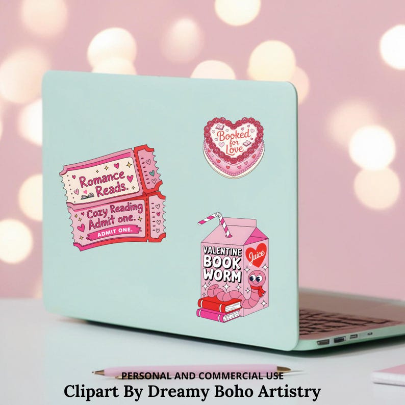 Op de afbeelding: Een laptop met stickers, waaronder een roze ticket met "Romance Reads" en "Cozy Reading Admit one", een hartvormige taart met "Booked for Love" en een roze sapbox met een boekenwurm en "Valentine Book Worm".