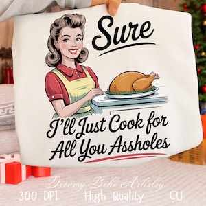 Könnte beinhalten: Eine weiße Tragetasche mit einer Retro-Illustration einer Frau in rotem Kleid und gelber Schürze, mit dem Text "Sure, I'll Just Cook for All You Assholes." Eine gebratene Pute liegt auf einem Teller.