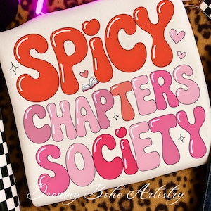 May include: Cream cushion featuring the text "SPICY CHAPTERS SOCIETY" in bubble letters. The words are in shades of red and pink, with heart and star motifs. The design has a retro, groovy style, reminiscent of the 1970s.
