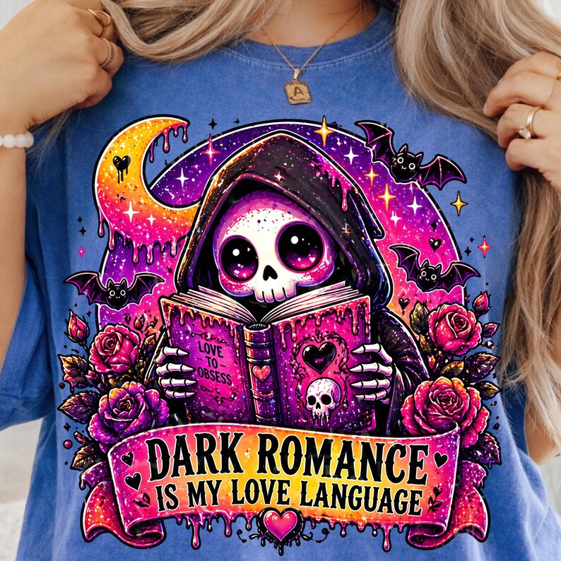 May include: Blue t-shirt featuring a cartoon Grim Reaper reading a book with the text "Love to Obsess." The design includes bats, roses, and the phrase "Dark Romance is my Love Language."