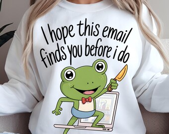May include: White sweatshirt with the text "I hope this email finds you before I do." A cartoon frog with a knife is standing on a laptop. The frog is green with a red bow tie and blue shorts. The sweatshirt has the Dreamy Boho Artistry logo.