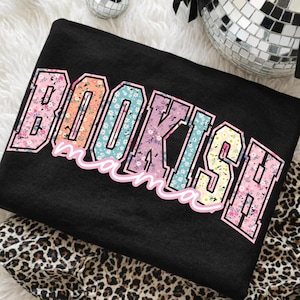 May include: Black sweatshirt with the text "BOOKISH mama" in a colorful floral design. The letters are outlined in pink and the floral patterns include pink, blue, yellow, and orange.