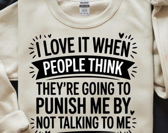 Könnte beinhalten: Beiges Sweatshirt mit schwarzem Text: "I LOVE IT WHEN PEOPLE THINK THEY'RE GOING TO PUNISH ME BY NOT TALKING TO ME". Das Sweatshirt hat einen Rundhalsausschnitt und lange Ärmel. Die Marke "GILDAN" ist sichtbar.