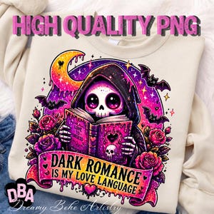 May include: Cream-colored sweatshirt featuring a graphic of a hooded skeleton reading a book with the text "DARK ROMANCE IS MY LOVE LANGUAGE." The design includes bats, roses, and a crescent moon in shades of pink, purple, and black.