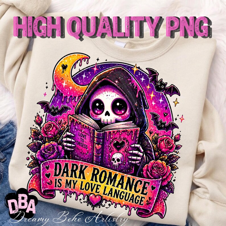 May include: Cream-colored sweatshirt featuring a graphic of a hooded skeleton reading a book with the text "DARK ROMANCE IS MY LOVE LANGUAGE." The design includes bats, roses, and a crescent moon in shades of pink, purple, and black.