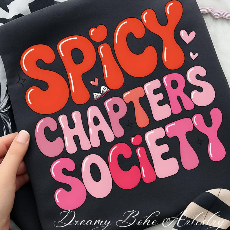 May include: Black fabric featuring the text "Spicy Chapters Society" in orange and pink bubble letters. Small hearts and a book graphic are included. The words "Dreamy Boho Artistry" are at the bottom of the fabric.