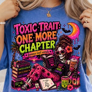 Puede incluir: Camiseta azul con un gr&aacute;fico colorido que presenta un esqueleto leyendo un libro con el texto "TOXIC TRAIT: ONE MORE CHAPTER". El dise&ntilde;o incluye libros, una taza de caf&eacute; y una luna creciente. El reloj muestra las 02:46 AM.