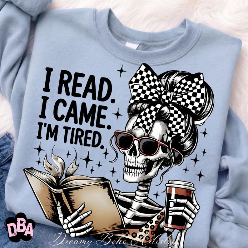 May include: Light blue sweatshirt with a graphic of a skeleton reading a book and holding a coffee cup. The skeleton wears sunglasses and a checkered bow. Text on the shirt reads: "I READ. I CAME. I'M TIRED."