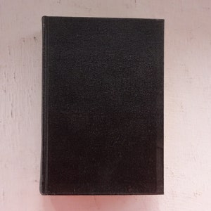May include: A black hardcover book with a textured cover.