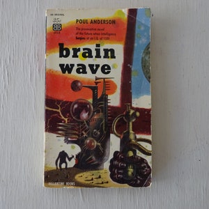 May include: A vintage paperback book cover with a colorful illustration of a futuristic scene. The title of the book is "Brain Wave" by Poul Anderson. The cover features a red, orange, and blue color scheme with a black and white illustration of a futuristic city.