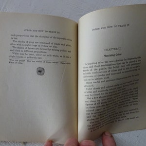 Peut inclure: Une page d'un livre vintage intitul&eacute; "La couleur et comment l'enseigner". La page traite de l'enseignement de la th&eacute;orie des couleurs et comprend un chapitre intitul&eacute; "Enseigner la couleur". Le texte d&eacute;crit l'utilisation de tableaux de couleurs, de fils et de papiers color&eacute;s pour illustrer les combinaisons de couleurs.