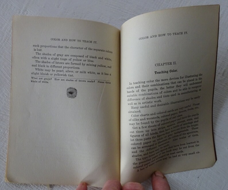 Peut inclure: Une page d'un livre vintage intitul&eacute; "La couleur et comment l'enseigner". La page traite de l'enseignement de la th&eacute;orie des couleurs et comprend un chapitre intitul&eacute; "Enseigner la couleur". Le texte d&eacute;crit l'utilisation de tableaux de couleurs, de fils et de papiers color&eacute;s pour illustrer les combinaisons de couleurs.